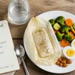 Assiette menu 800 calories par jour avec poisson, légumes et œufs